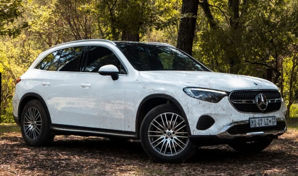 Muddy white Mercedes-Benz GLC Coupe parked on a woodland trail, perfectly blending its "couturier suit" elegance with genuine off-road capabilities