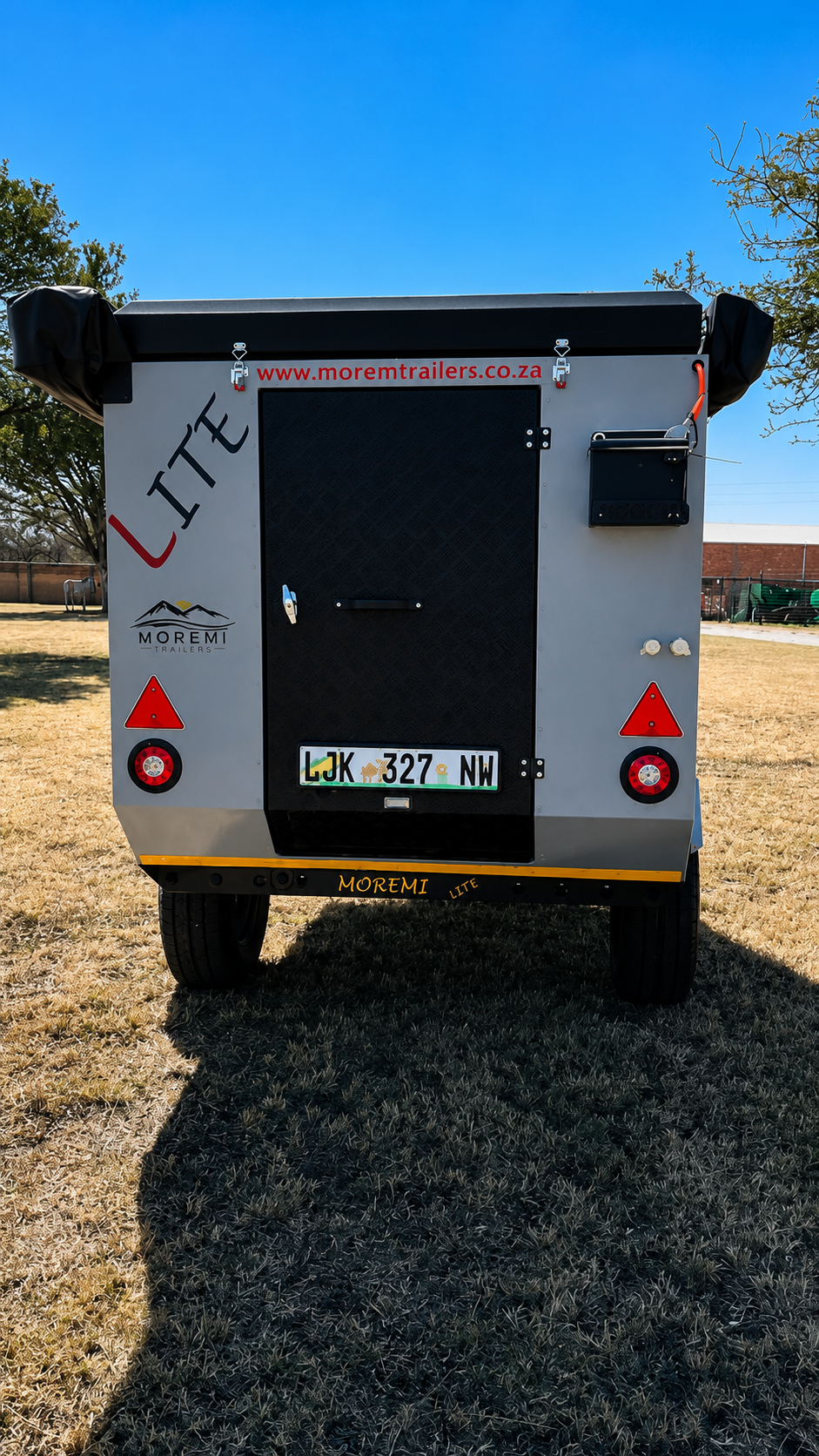 Rear view of the Moremi Lite trailer showing the entry door, lights, number plate and Moremi Trailers branding.