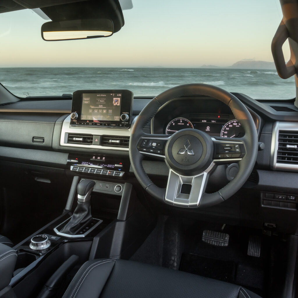 The dashboard of the Mitsubishi Next-Gen Triton with the entertainment system, navigation system and the view from the front window. 