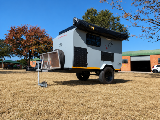 Front-angle view of the lightweight Moremi Lite trailvan with spare wheel, stone guard and folded awning